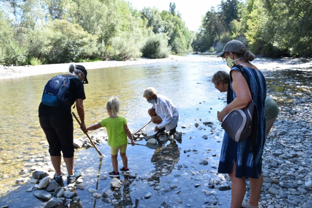 Famille participant à la visite d'un cours d'eau organisée par le SILA